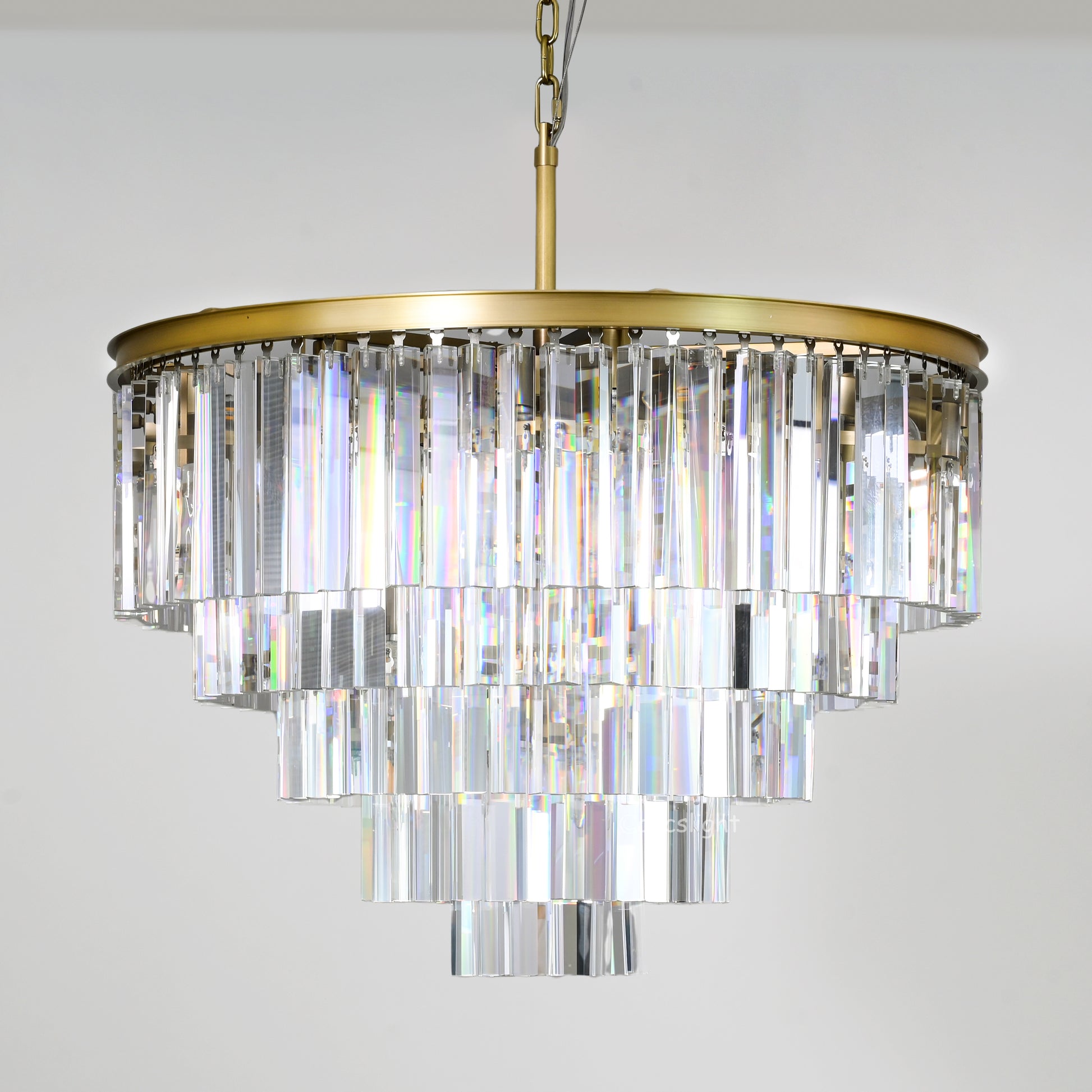 Crystal chandelier with gold fixture on a light gray background