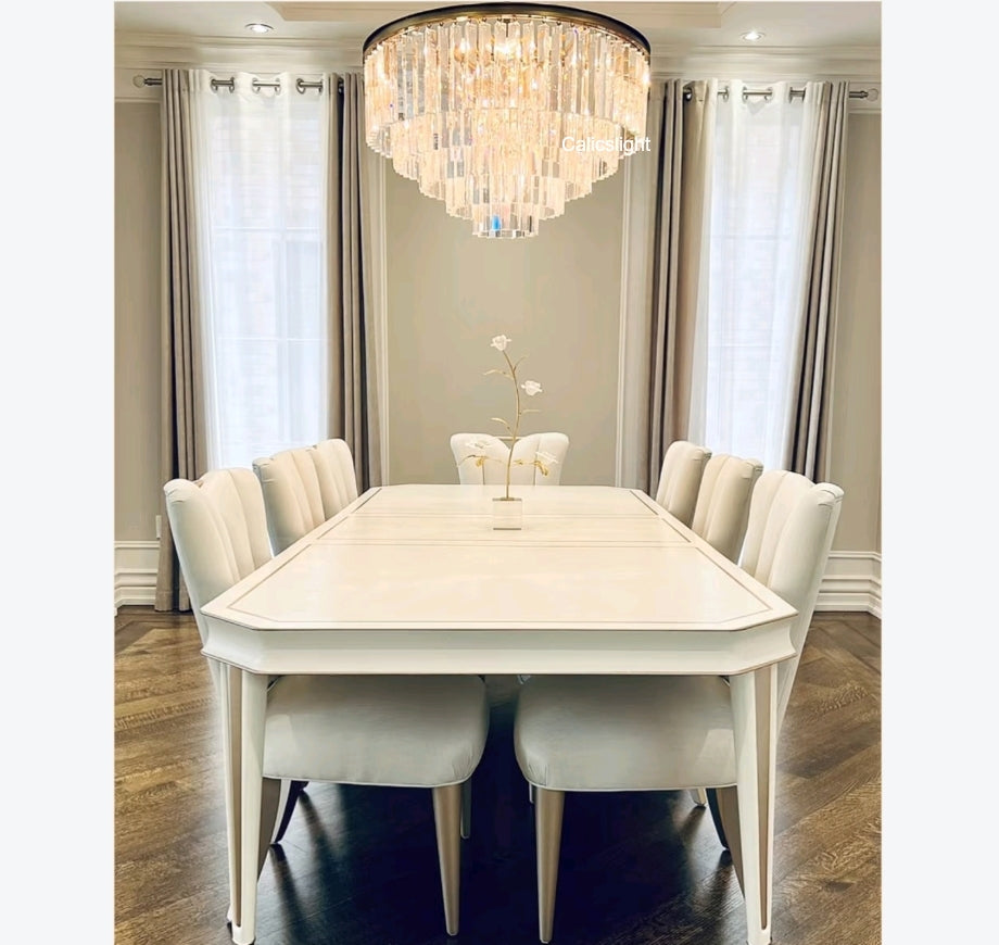 Dining room with a white table and chairs under a chandelier.