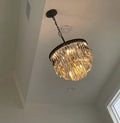 Chandelier hanging from the ceiling in a room with white walls.