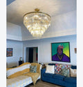 Living room with a chandelier, blue sofa, and colorful artwork on the wall.