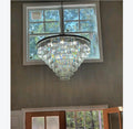 Chandelier hanging in front of a window with trees outside