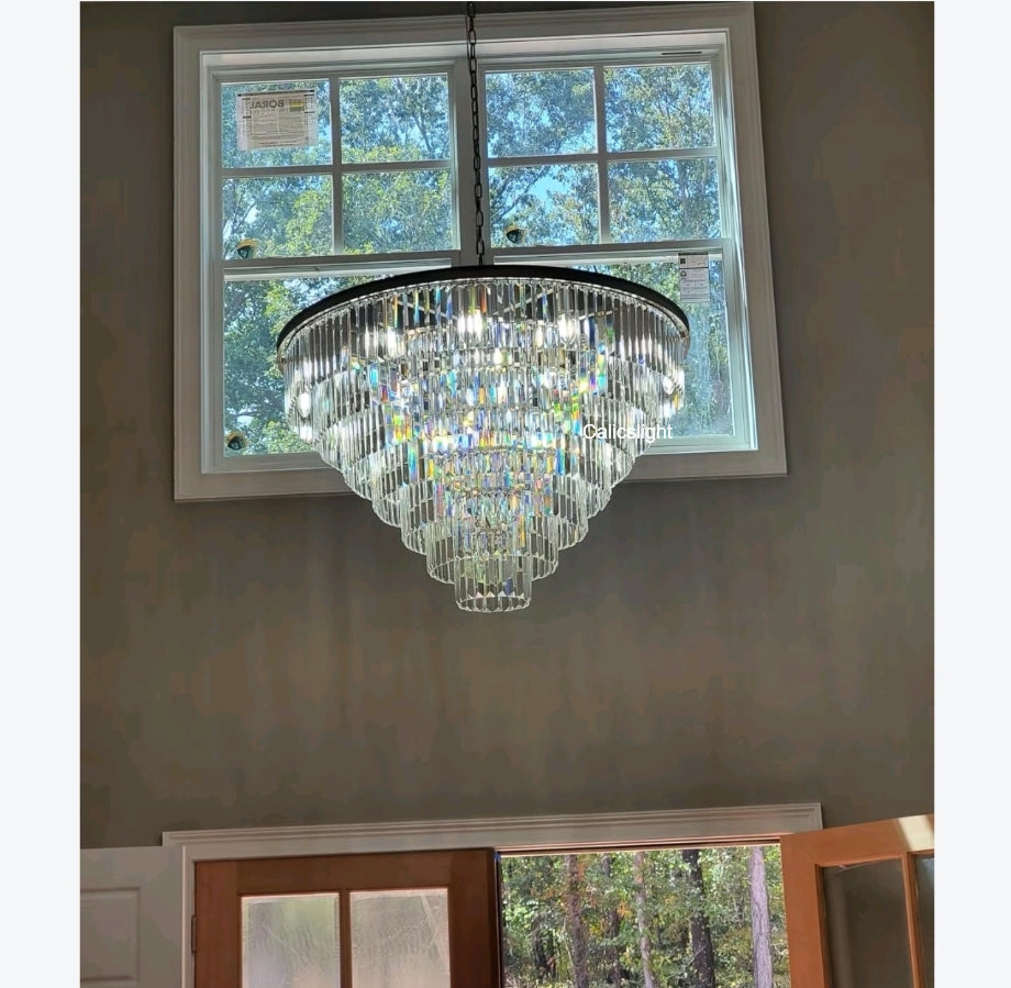Chandelier hanging in front of a window with trees outside